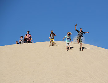 Familie med børn leget i sandet ved Rubjerg Knude Fyr