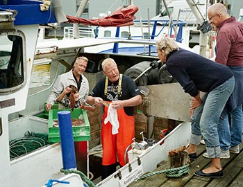 Fisker sælger fisk fra sin båd i Hirtshals havn